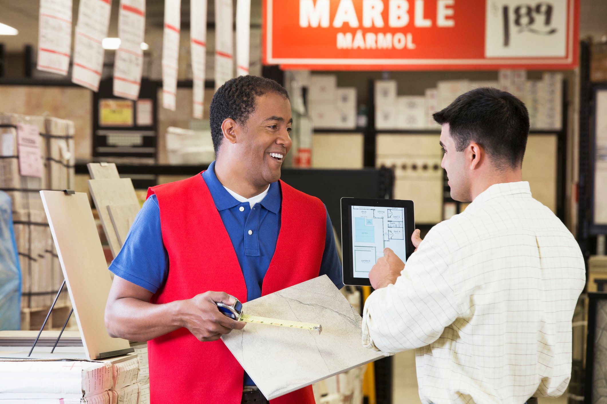Worker and contractor discussing plans in home-improvement store.