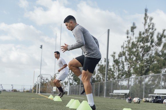Two soccer players practicing drills on a soccer field.