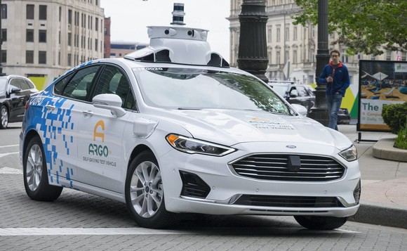 A Ford Fusion sedan with two Velodyne lidar sensors visible at the top of its rooftop sensor stack. 