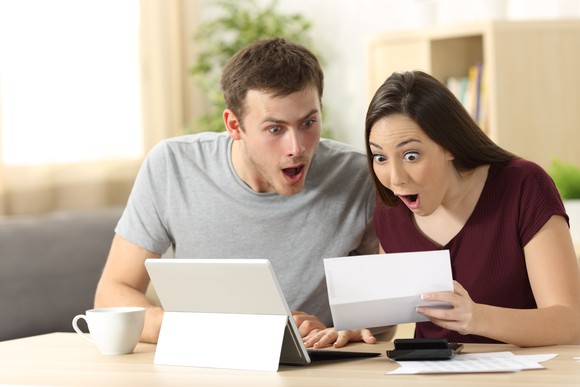 Two people looking at a paper in surprise.