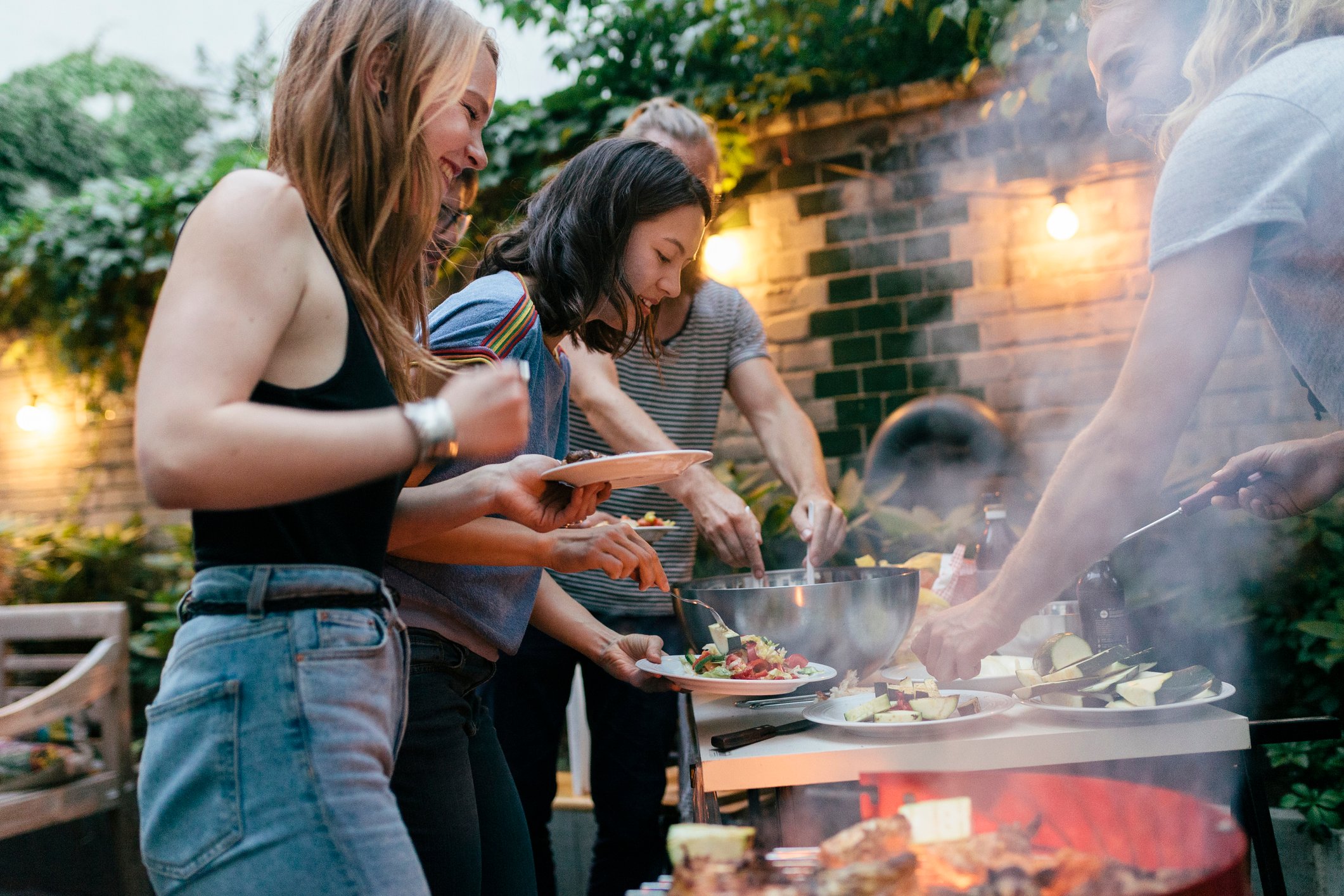 People helping themselves to food at a barbecue party.