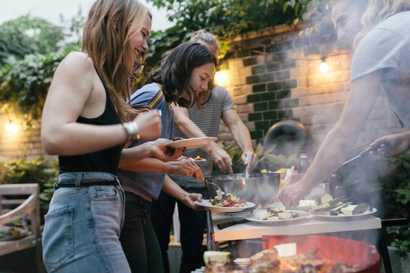 People helping themselves to food at a barbecue party.