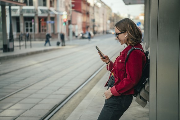 Surfing the web while waiting for a tramway. 
