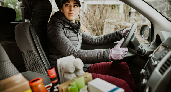 Person in a car delivering groceries.