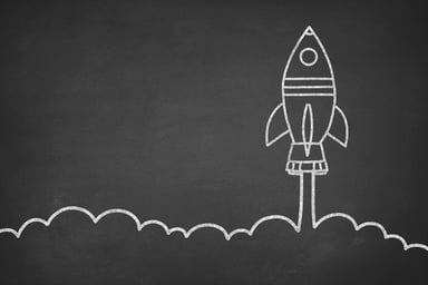 A chalkboard illustration of a rocket lifting off.