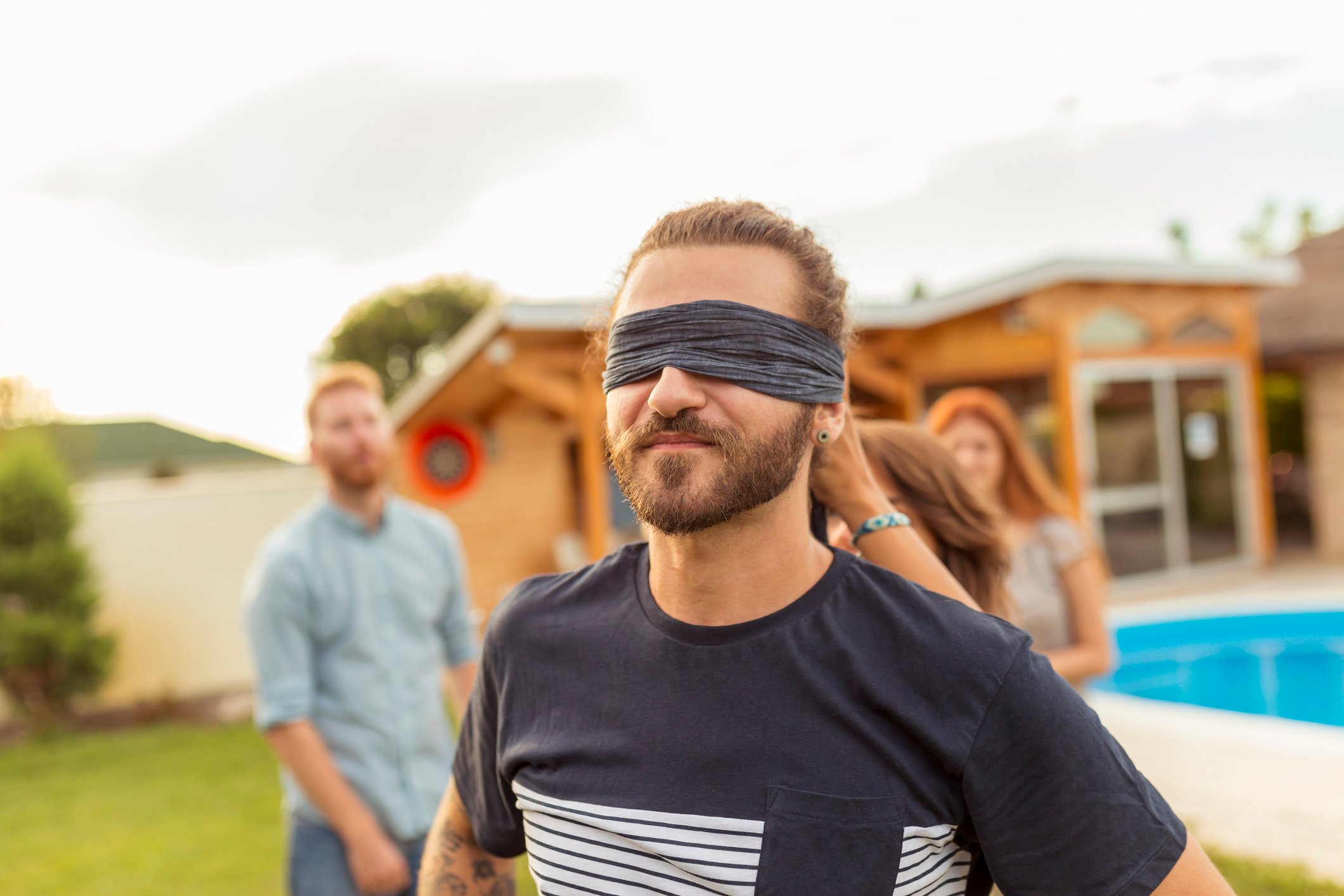 A blindfolded man at a party.