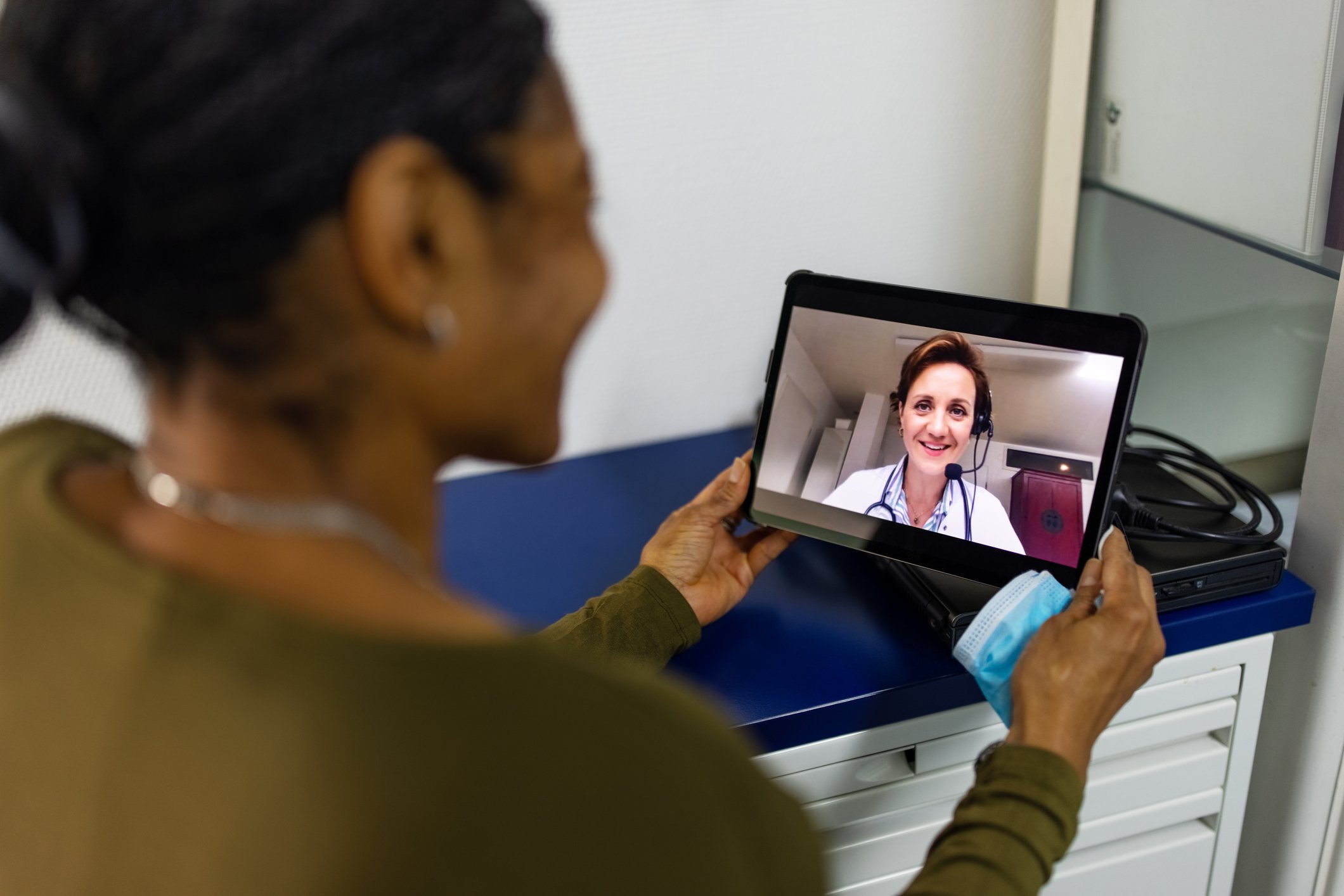 A patient having a virtual visit with a doctor through a tablet.