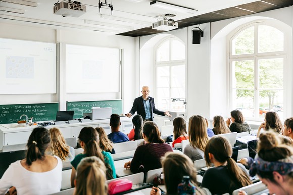 A professor gives a lecture to a classroom of college students.