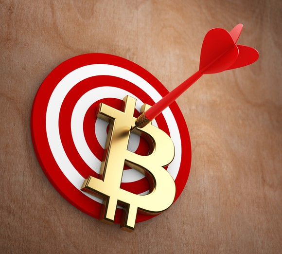 Bitcoin symbol pinned to a dartboard