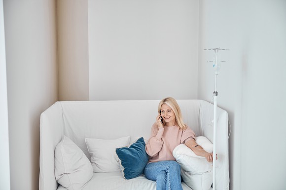 Patient sitting on a couch while having IV therapy.