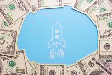 A drawing of a rocket surrounded by cash.