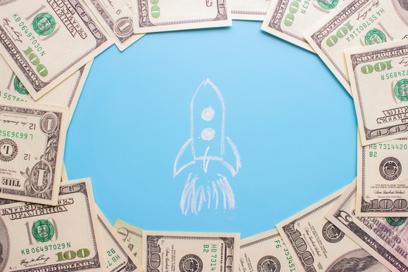 A drawing of a rocket surrounded by cash.