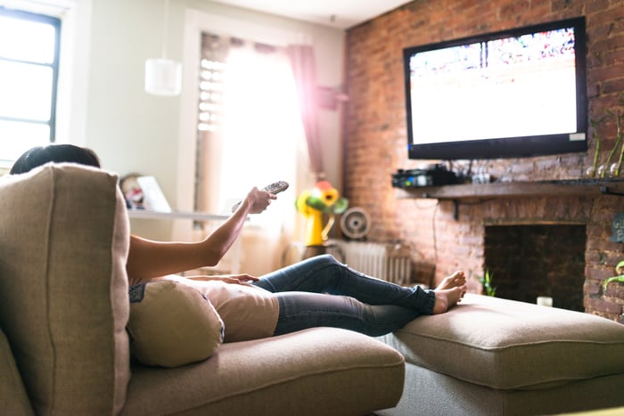 A person relaxing on a sofa while watching TV.