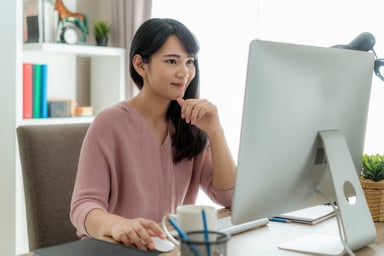 Woman seated at a desk using a PC