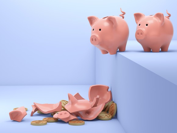 Piggy banks lining up to fall off a step. 