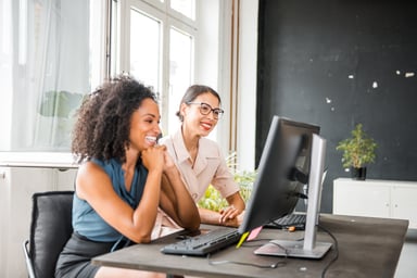 Similing women work on a computer.