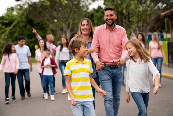 Smiling adults and children walking together.