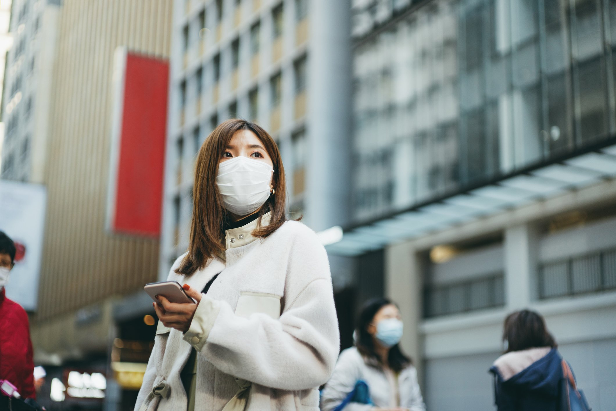 Young Chinese woman using her smartphone in the city.