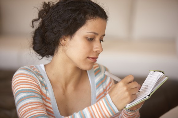 A family member writes in a checkbook.