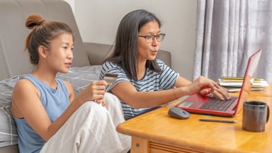 People looking at a laptop.
