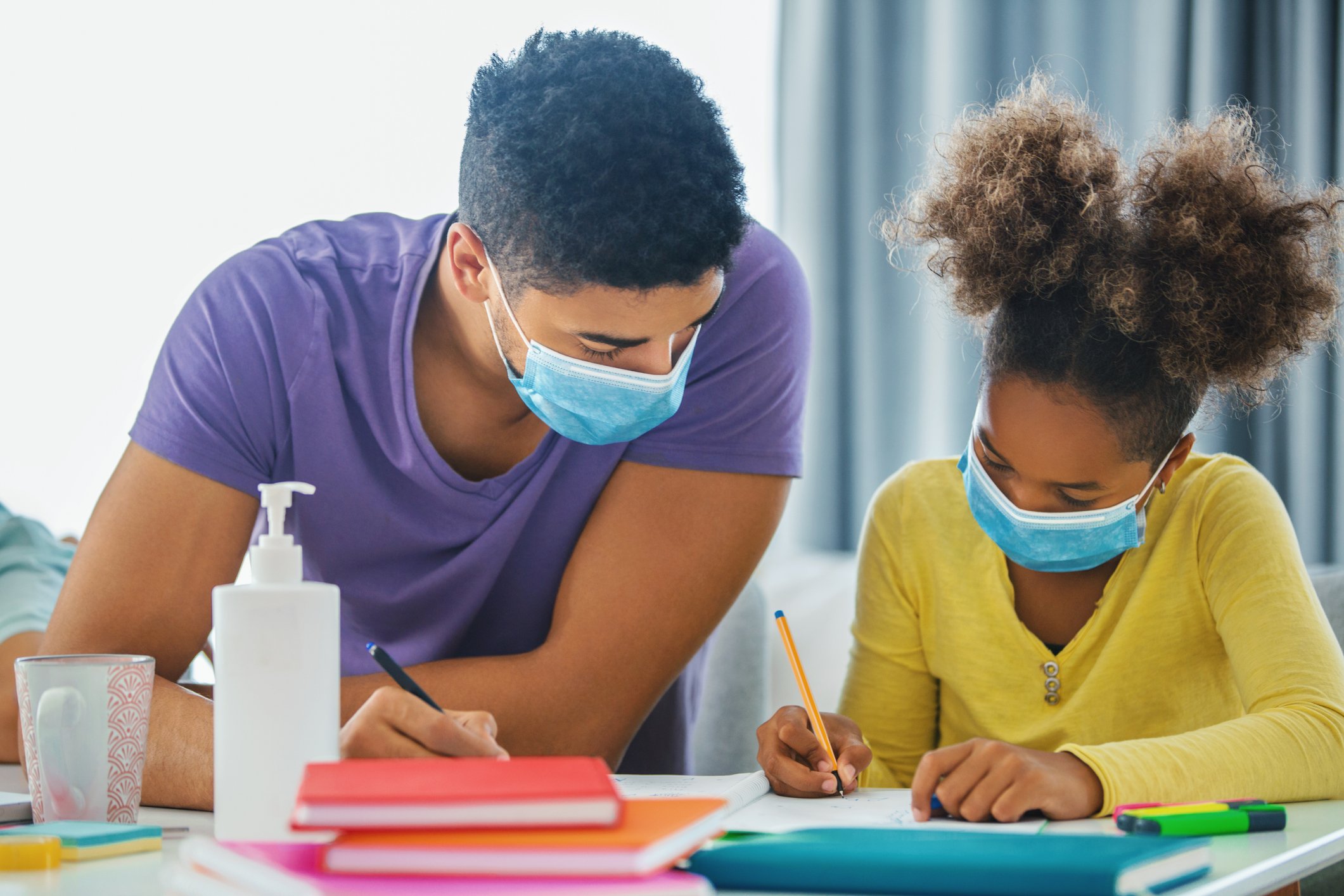 Adult helping child with school work. 