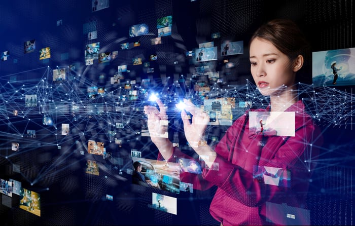 A person sorts and clicks an array of tiny screens floating around them.