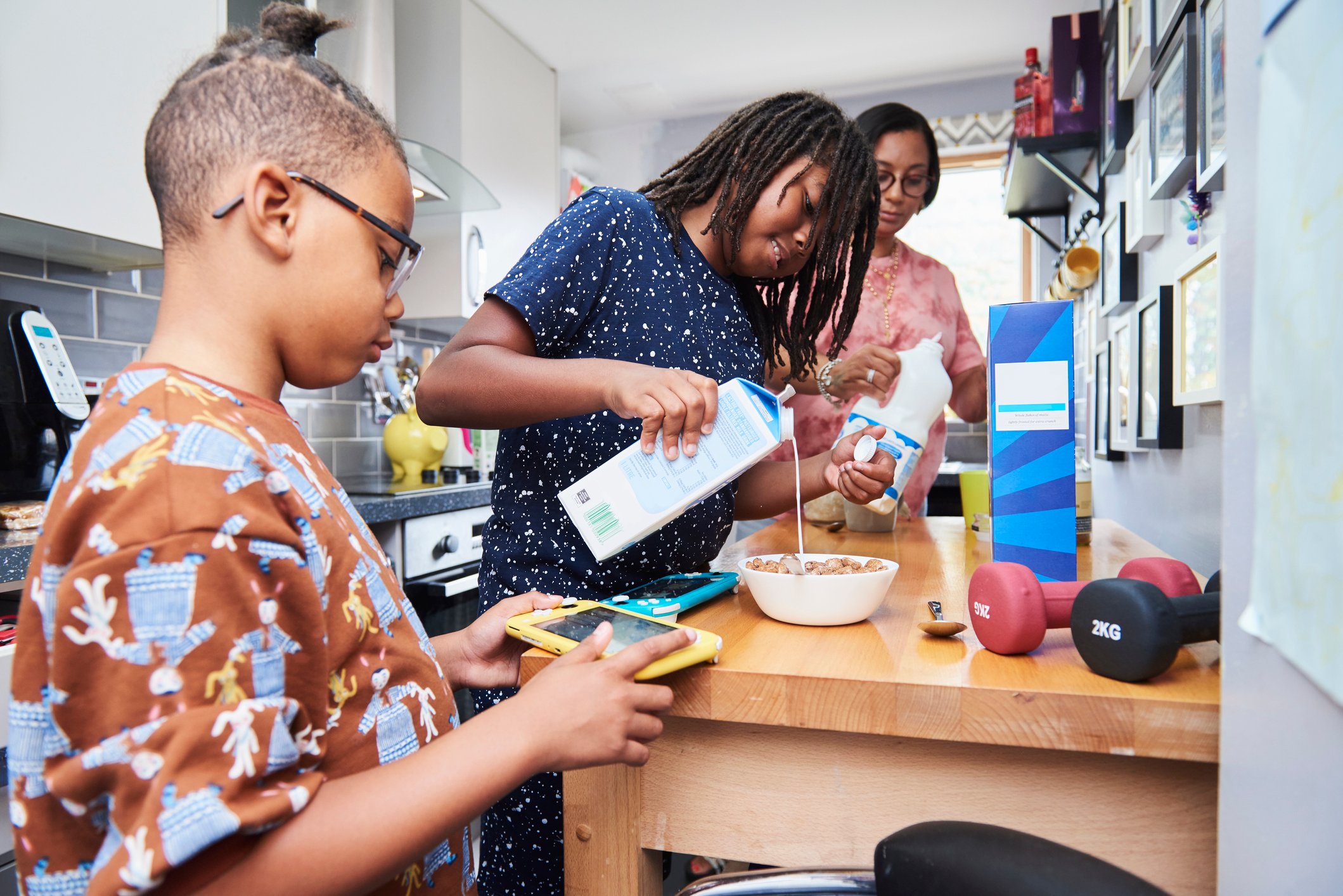 A family pouring milk into cereal bowls.