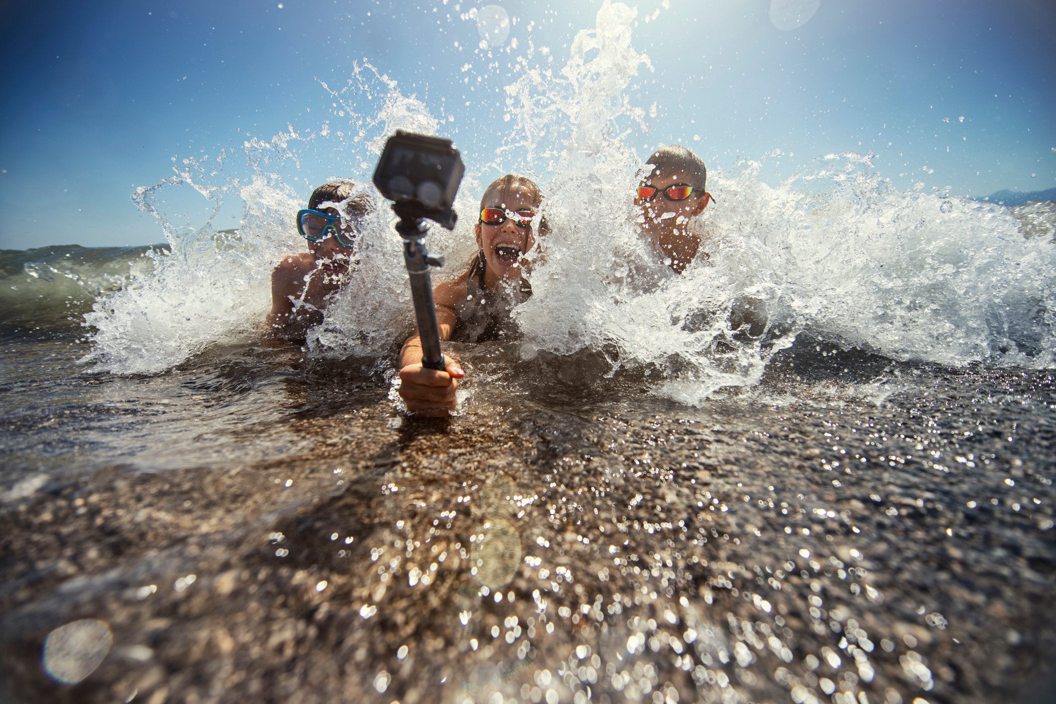 Kids using an action camera to film them splashing in the waves. 