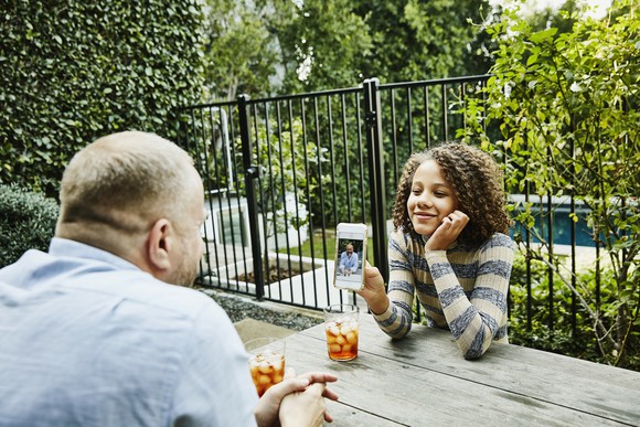 Family sharing a picture at an outdoor table.