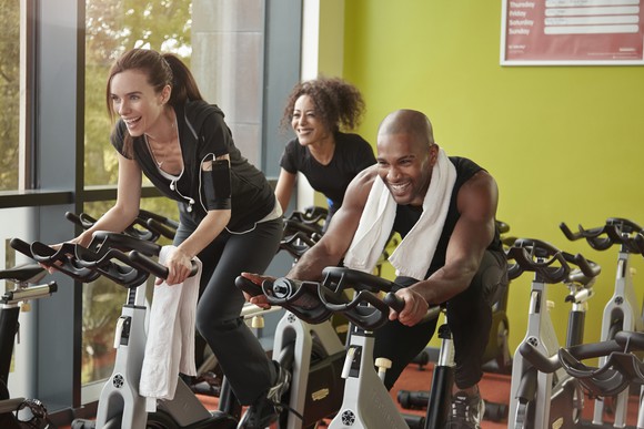 Three people on exercise bikes.