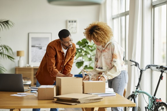 Two people boxing orders at an e-commerce business.