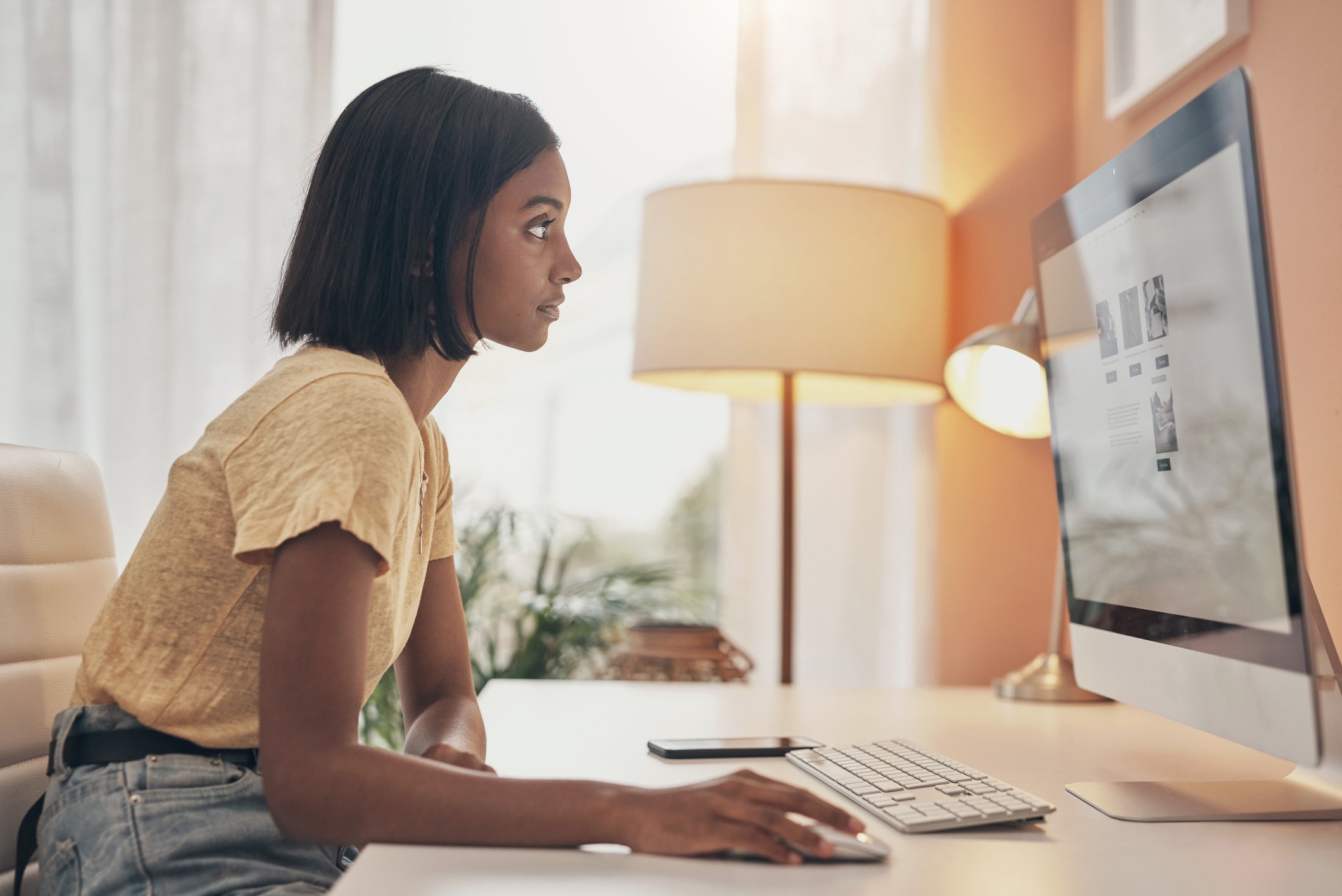 Investor sitting at her computer, reviewing financial news.
