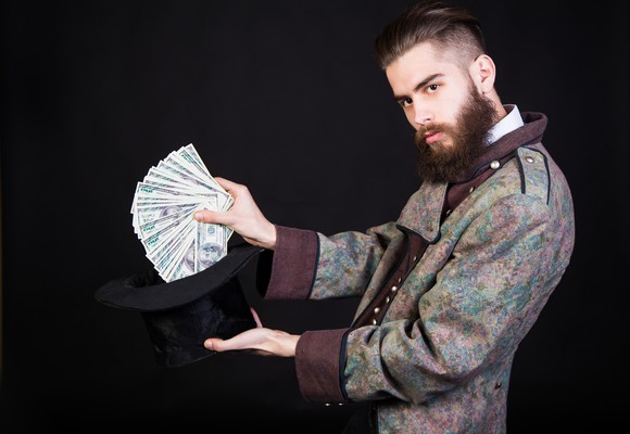 Magician pulling a bunch of cash from a hat.