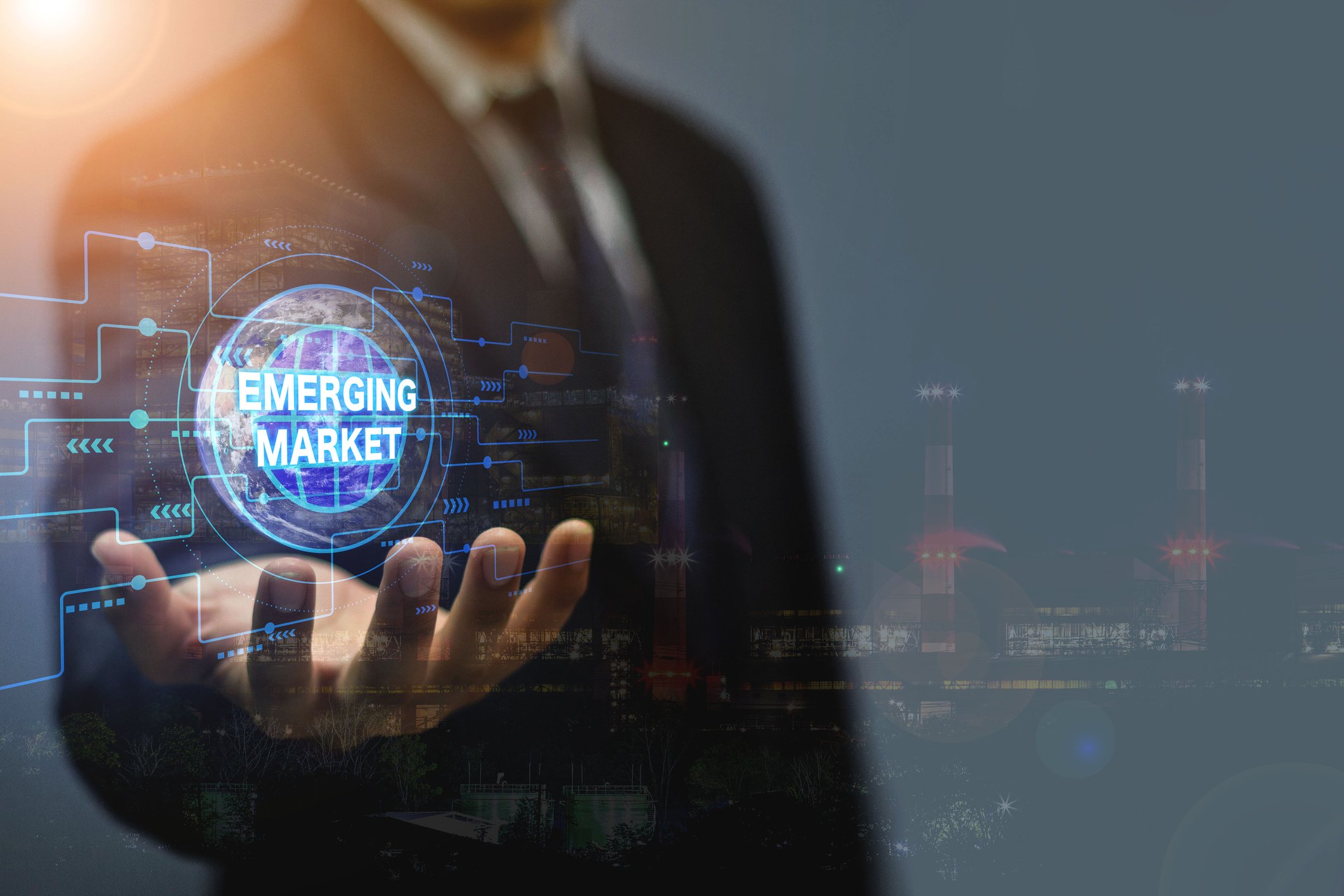 A person in a business suit holding a floating digital sphere labeled Emerging Market.