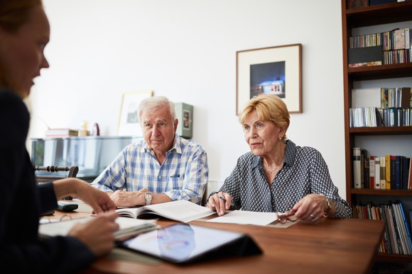A couple sitting with an advisor going over taxes.