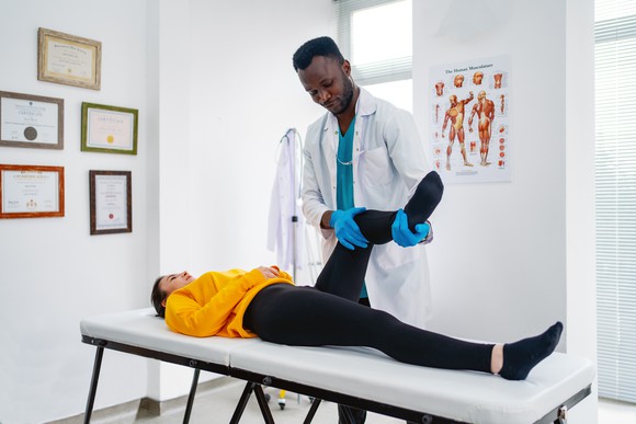 A chiropractor treating a patient's injured knee.