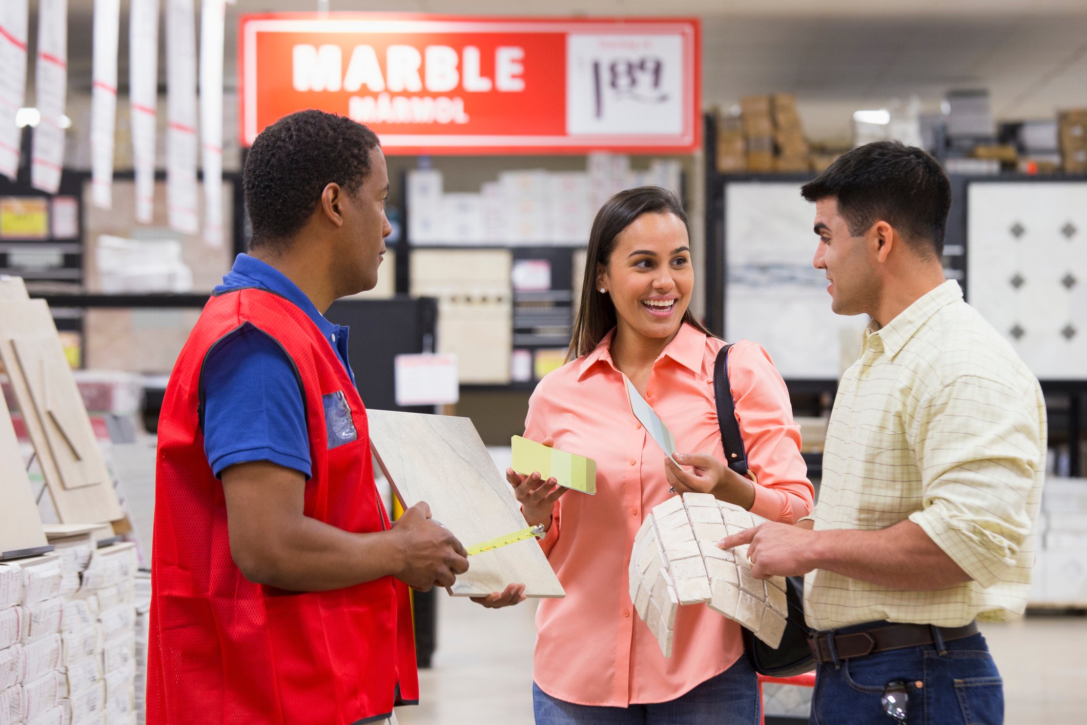 two customers with a sales associate at home improvement store
