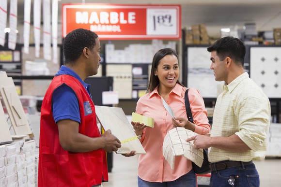 two customers with a sales associate at home improvement store