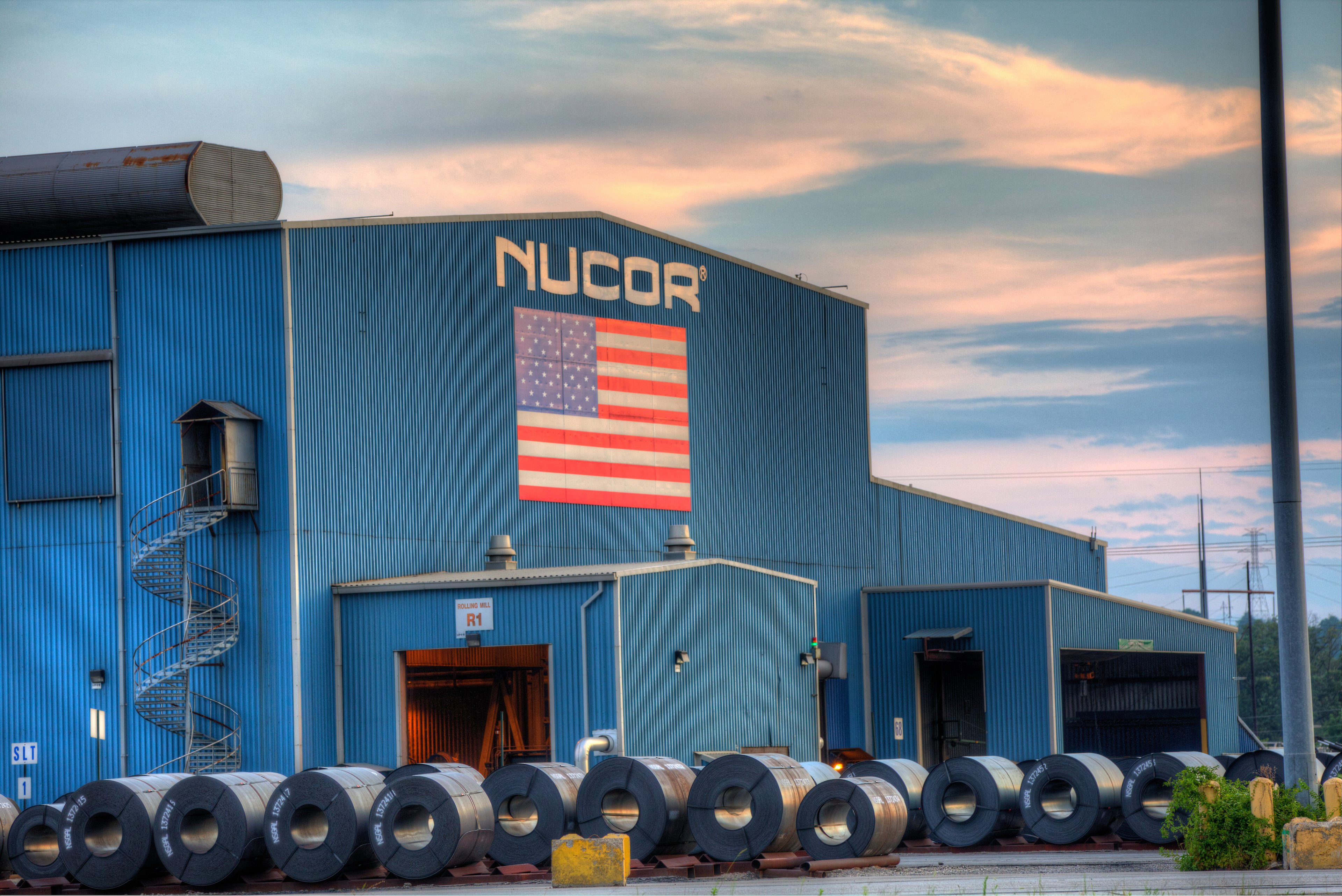 Nucor steel mill in Gallatin Kentucky with American flag on front of building.