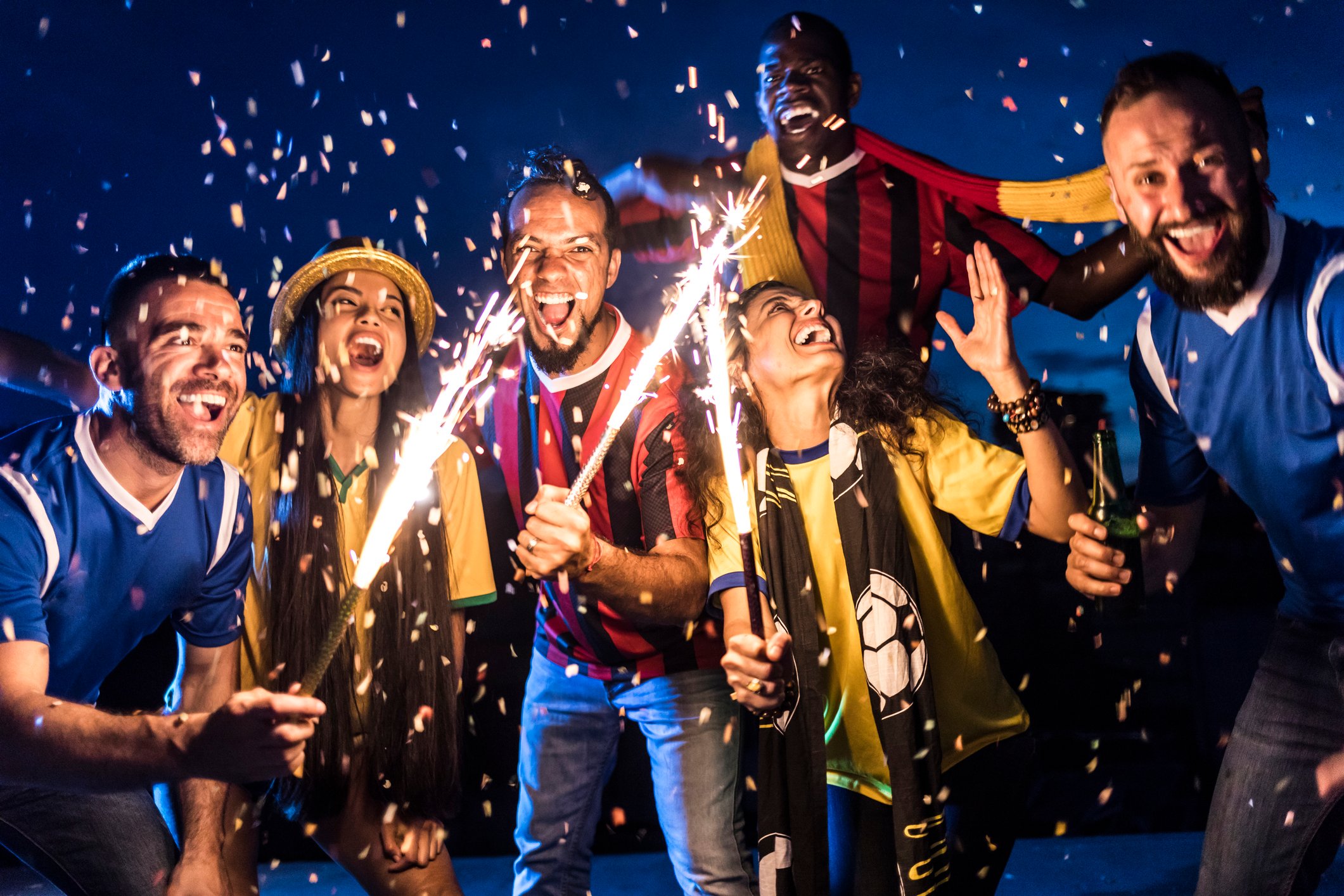 Six people with sparklers and fireworks.