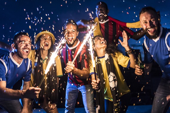 Six people with sparklers and fireworks.