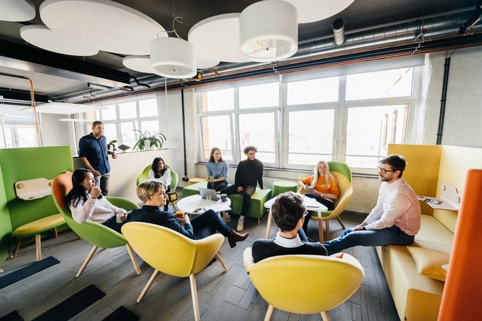 Group of workers meet in a colorful office.