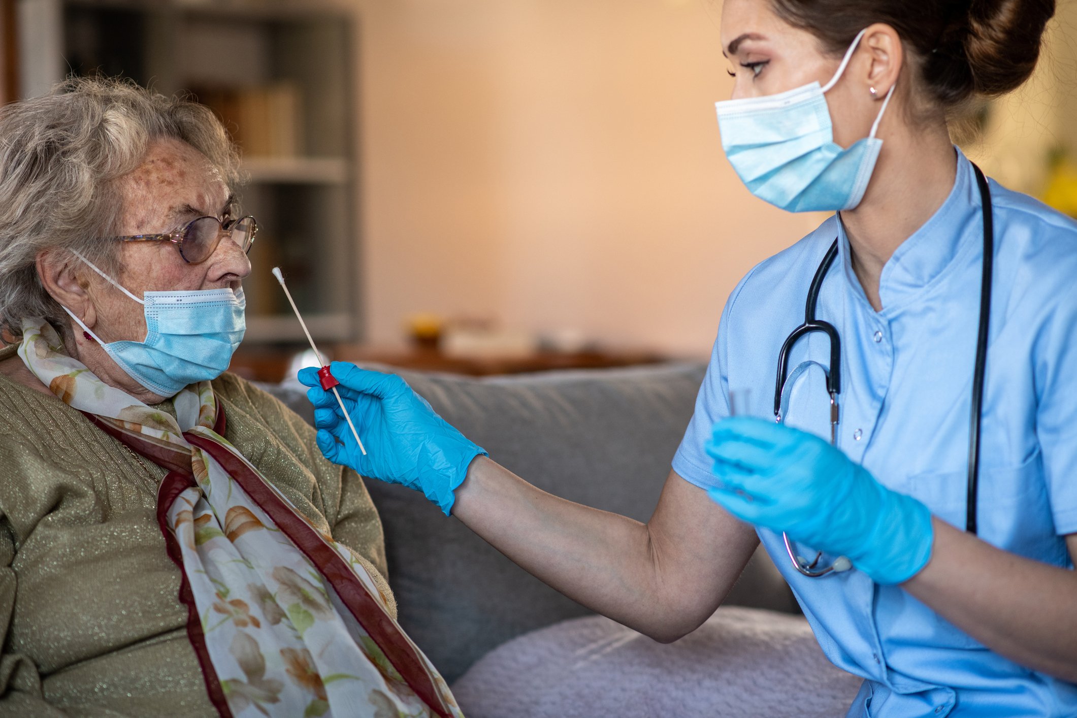 A clinician tests a patient for COVID.