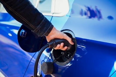 A person charging an electric vehicle.