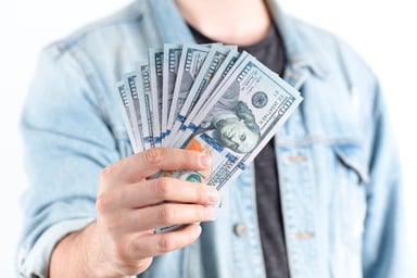 man holding stack of hundred dollar bills
