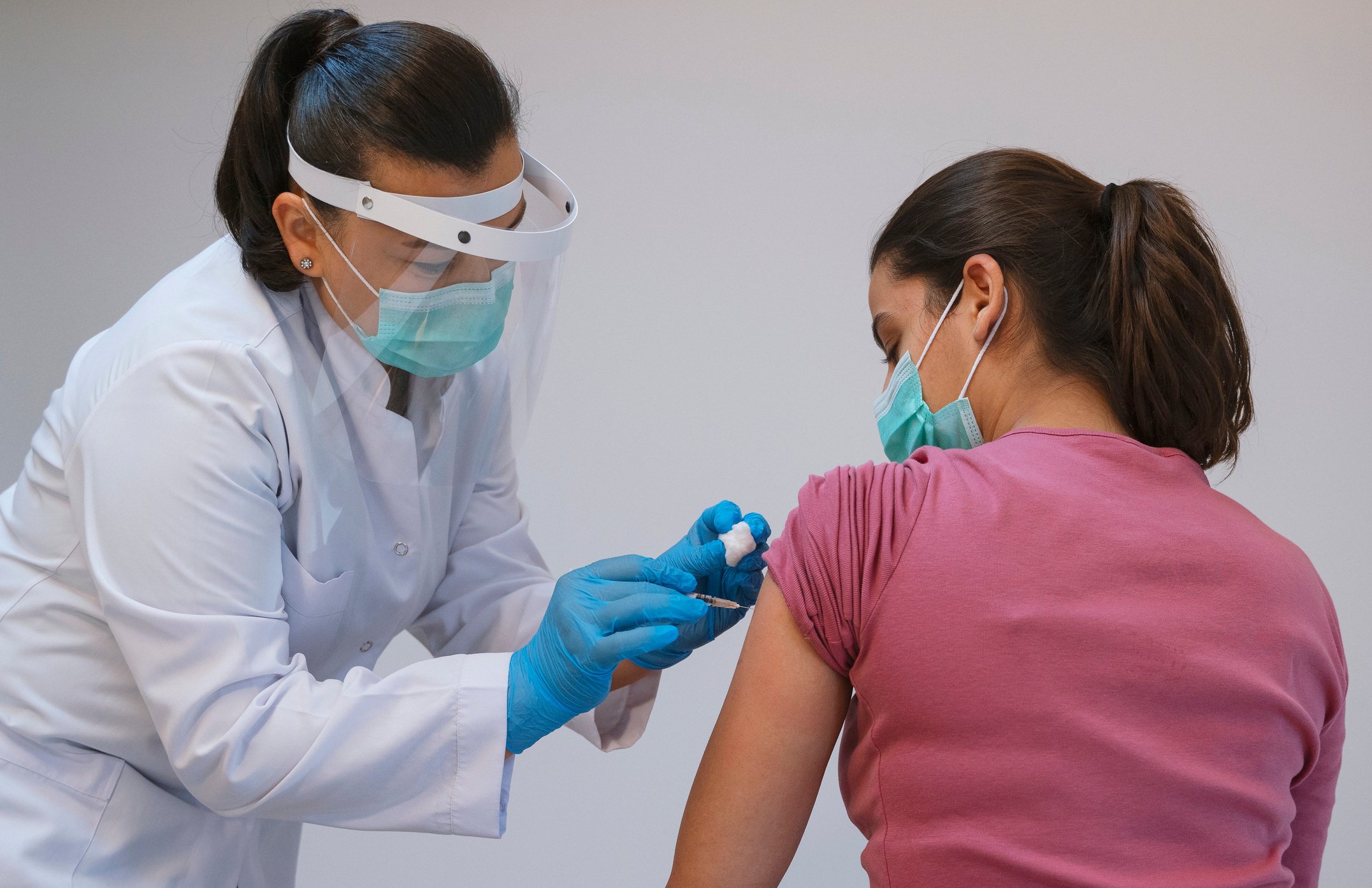A clinician gives a patient a vaccination shot.