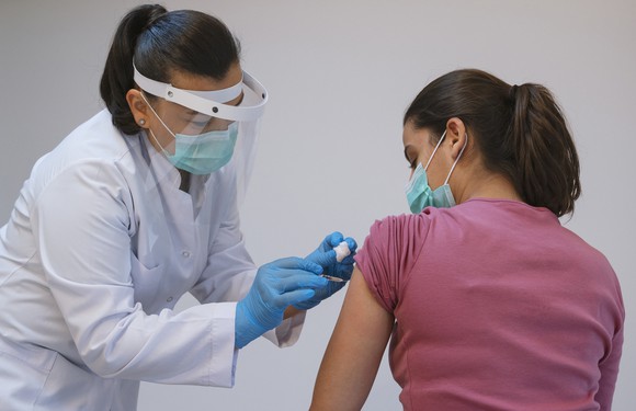 A clinician gives a patient a vaccination shot.