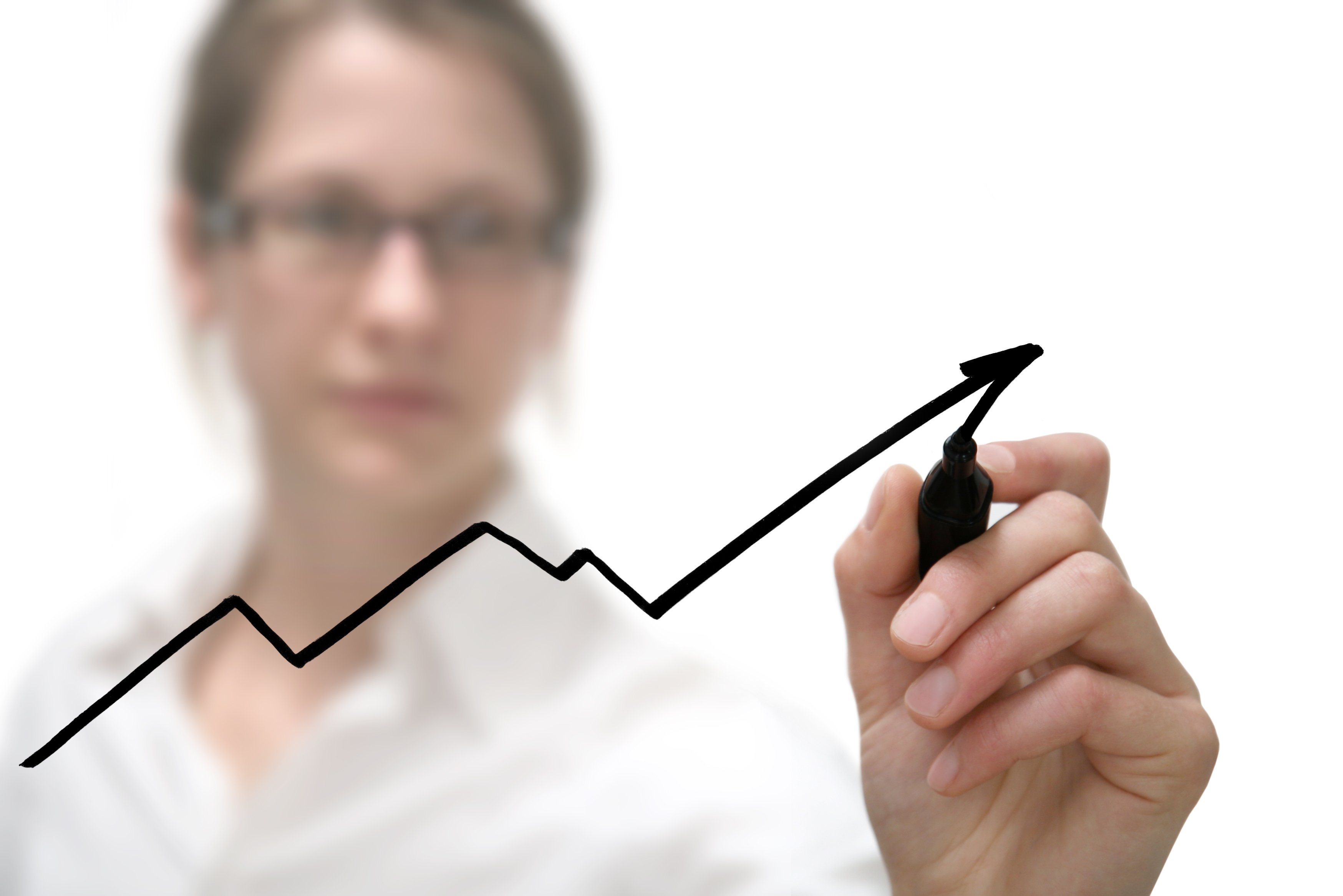 A person drawing a line on a graph up and to the right.