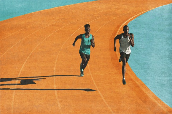 Two people running on a bright orange track with a light blue border.