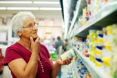 woman holding can in grocery store
